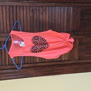 Small pink/peach tank top, light/breathable material. Open sides